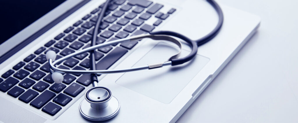 Laptop with a stethoscope lying on keyboard